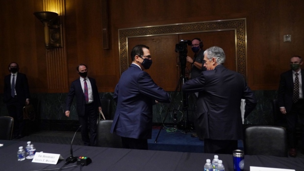 WASHINGTON, DC - SEPTEMBER 24: Steven T. Mnuchin, Secretary, Department of the Treasury, left, elbow bumps Jerome H. Powell, Chairman, Board of Governors of the Federal Reserve System, after the Senate's Committee on Banking, Housing, and Urban Affairs hearing examining the quarterly CARES Act report to Congress on September 24, 2020 in Washington, DC. The Coronavirus Aid, Relief, and Economic Security Act, also known as the CARES Act, is a $2.2 trillion economic stimulus bill passed in response to the economic fallout of the COVID-19 pandemic in the United States. (Photo by Toni L. Sandys-Pool/Getty Images)