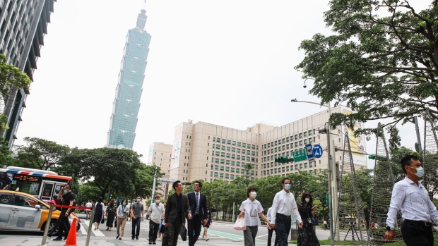People walk in the Xinyi district as the Taipei 101 building stands in the distance in Taipei, Taiwan, on Tuesday, June 2, 2020. Taiwan cut its full-year growth forecast as the coronavirus outbreak threatens jobs at home and decimates overseas demand.