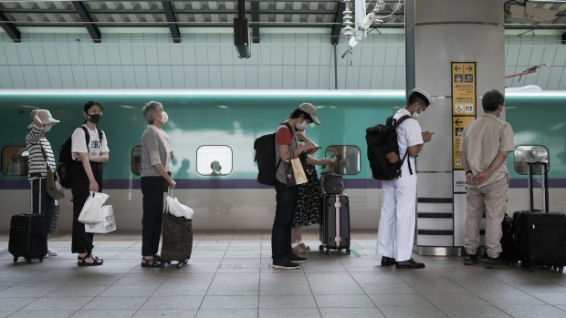 Passengers line up waiting to aboard an East Japan Railway Co. (JR East) Shinkansen the bullet train on a platform of Tokyo Station in Tokyo, Japan, on Aug. 7, 2020. Mid-August is a traditional time for many Japanese to leave the densely populated cities and travel to meet family in rural areas. But reservations of the bullet trains over this year’s Obon period are at just 16% of last year’s, according to JR East.