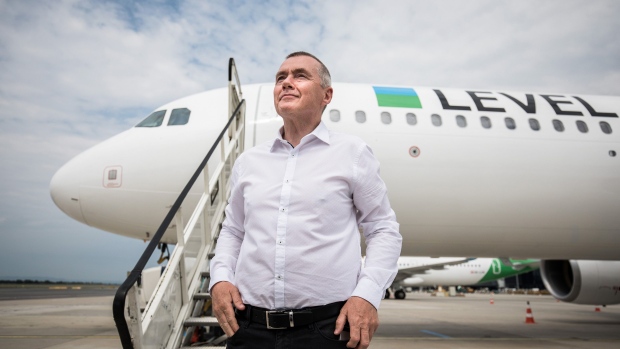 FILE: Willie Walsh, chief executive officer of International Consolidated Airlines Group SA (IAG), poses for a photograph in front of a passenger aircraft during an event to launch the Austrian base for low-cost brand Level, operated by International Consolidated Airlines Group SA (IAG), at Vienna International Airport in Vienna, Austria, on Tuesday, July 17, 2018