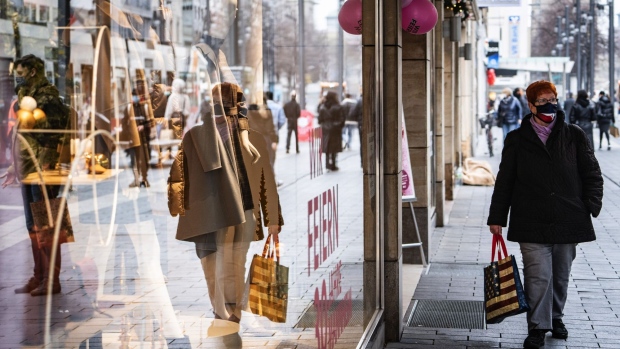 A shopper wearing a protective face mask passes a retail outlet in Mannheim, Germany, on Thursday, Nov. 12, 2020. The pandemic will cause slightly less damage to Germany’s economy than expected this year as government aid helps offset the effect of virus- containment measures, the country’s top advisers said. Photographer: Peter Juelich /Bloomberg