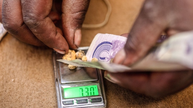 Prisca Muchokore, manager of DT Mining Syndicates, places small balls of mined gold onto a scale to weigh and calculate payment for the artisanal miners at a small-scale gold mine in Umguza, Zimbabwe, on Saturday, Nov. 10, 2018. On January 1, the London Bullion Market Association will introduce a new version of guidelines for the Responsible Gold Guidance program that embrace what’s called environmental, social and governance standards.
