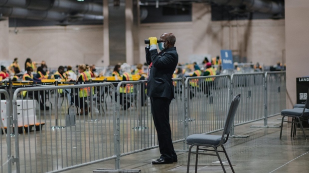 An official poll watcher uses binoculars as workers count ballots for the 2020 Presidential election at the Philadelphia Convention Center in Philadelphia, Pennsylvania, U.S., on Tuesday, Nov. 3, 2020. Philadelphia officials said Monday it "will easily take several days" to count the city's large number of mail-in ballots, potentially delaying statewide election results from Pennsylvania that could decide a close presidential race. Photographer: Hannah Yoon/Bloomberg