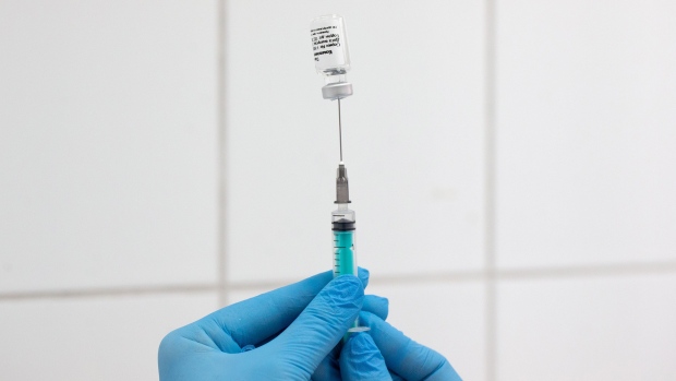 A health worker draws the 'Gam-COVID-Vac', also known as 'Sputnik V', COVID-19 vaccine, developed by the Gamaleya National Research Center for Epidemiology and Microbiology and the Russian Direct Investment Fund (RDIF), from a vial during a trial at the City Clinic #2 in Moscow, Russia, on Thursday, Nov. 26, 2020. Developers of Russia’s flagship vaccine, Sputnik V, said that initial testing showed it was 91.4% effective in preventing infections, although it has not yet published final results in a peer-reviewed journal. Photographer: Andrey Rudakov/Bloomberg