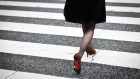 A pedestrian crosses a street in Tokyo, Japan, on Feb. 8, 2019. Women