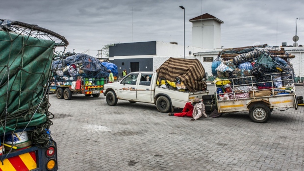A delivery driver fixes a truck loaded with goods at Beitbridge border station near the border crossing with Zimbabwe, near Musina, South Africa, on Tuesday, Dec. 17, 2019. Delivery drivers, or malaichas, a slang term meaning "deliverer of goods", transport items between South Africa's commercial hub, Johannesburg, and Zimbabwe’s capital, Harare.