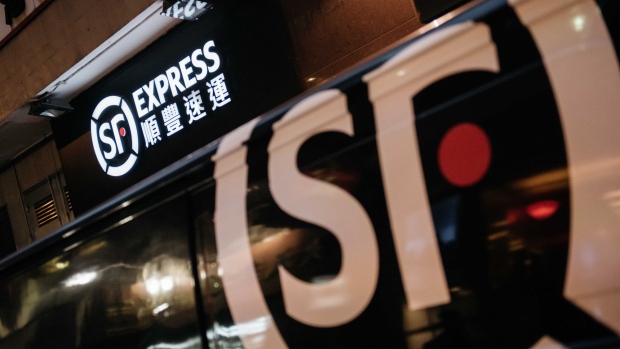 Signage for S.F. Express is displayed atop one of the courier's stores in Hong Kong, China, on Friday, Feb. 10, 2017. Last week's official launch of S.F. Express's so-called backdoor listing on the Shenzhen Stock Exchange, approved in December and pushed through rapidly with government support, helped produce a 59 percent surge in shares of parent S.F. Holding Co., giving founder Wang Wei a net worth $24.1 billion on the Bloomberg Billionaires Index. Photographer: Anthony Kwan/Bloomberg