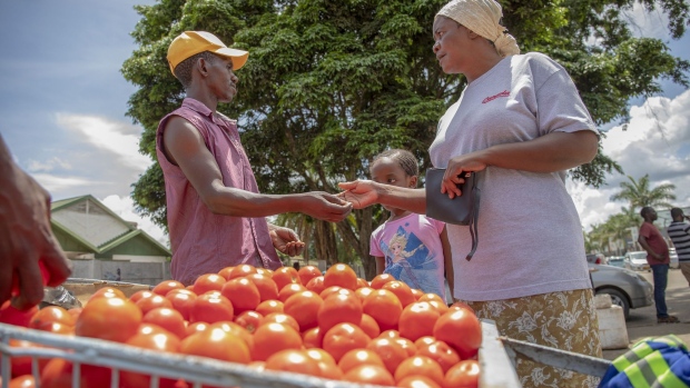A customer pays a vendor for fresh tomatoes at a market in Harare, Zimbabwe, on Thursday, Jan. 17, 2019. Hopes of an economic revival in Zimbabwe lie in tatters 14 months after President Emmerson Mnangagwa took office, as the nation reels from foreign-exchange and fuel shortages, strikes and a dearth of political leadership. Photographer: Cynthia R Matonhodze/Bloomberg