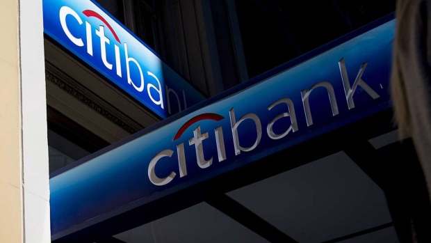 The silhouette of a pedestrian holding a mobile device is seen walking past a Citigroup Inc. bank branch in San Francisco. Photographer: David Paul Morris/Bloomberg