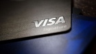 A Visa Inc. credit card is arranged for a photograph in Tiskilwa, Illinois, U.S., on Tuesday, Sept. 18, 2018. Visa and Mastercard agreed to pay as much as $6.2 billion to end a long-running price-fixing case brought by merchants over card fees, the largest-ever class action settlement of an antitrust case.