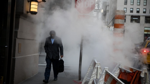 A pedestrian passes in front of a tube releasing a cloud of steam near the New York Stock Exchange (NYSE) in New York, U.S., on Monday, Jan. 7, 2019. U.S. stocks climbed following last week's rally with investors piling into small-capitalization stocks amid the resumption of trade talks with China. Photographer: Michael Nagle/Bloomberg