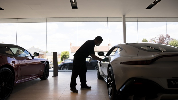 A worker polishes an Aston Martin Vantage in a showroom at the Aston Martin Works dealership, operated by the Aston Martin Lagonda Global Holdings Plc, in Newport Pagnell, U.K., on Monday, June 1, 2020. Outdoor markets and car showrooms are able to reopen from June 1, as soon as they meet the coronavirus guidelines to protect shoppers and workers. Photographer: Jason Alden/Bloomberg