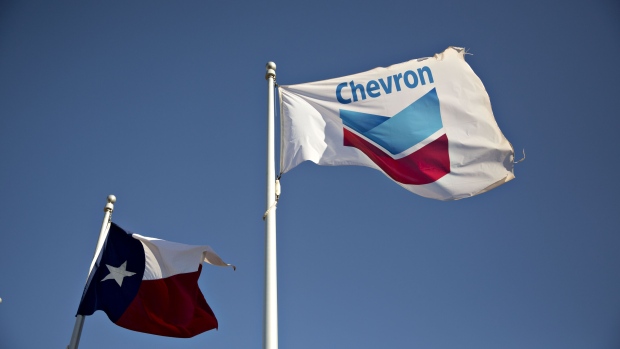 Lone Star and Chevron Corp. flags fly outside an office building in Midland, Texas, U.S., on Thursday, March 1, 2018.