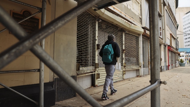 A pedestrian walks past a closed stores in Newark, New Jersey, U.S., on Wednesday, Nov. 25, 2020. Newark, New Jersey’s largest city, issued a stay-at-home advisory from November 25 to December 4, shutting down all non essential businesses to curb the rising Covid-19 cases. Photographer: Angus Mordant/Bloomberg