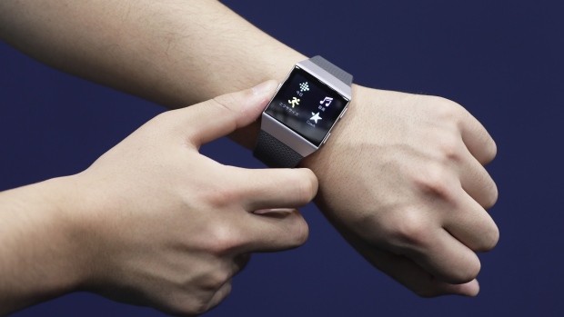 An attendant shows a Fitbit Inc. Ionic smartwatch. Photographer: Kiyoshi Ota/Bloomberg