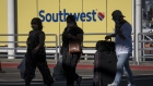Travelers wearing protective masks walk past Southwest Airlines Co. signage at Oakland International Airport in Oakland, California, U.S., on Monday, Oct. 19, 2020. Southwest Airlines is expected to release earnings figures on Oct. 22. Photographer: David Paul Morris/Bloomberg