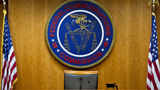 The Federal Communications Commission (FCC) seal hangs inside a meeting room at the headquarters ahead of a open commission meeting in Washington, D.C., U.S., on Thursday, Dec. 14, 2017. The FCC is slated to vote to roll back a 2015 utility-style classification of broadband and a raft of related net neutrality rules, including bans on broadband providers blocking and slowing lawful internet traffic on its way to consumers. Photographer: Andrew Harrer/Bloomberg