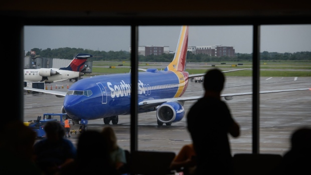 A person watches as a Southwest Airlines Co. plane arrives at a gate at the Pittsburgh International Airport (PIT) in Moon Township, Pennsylvania, U.S., on Tuesday, July 2, 2019. Programs adopted or being considered by a number of airports allow people beyond security checkpoints so they can meet arriving relatives or just hang out as airports expand options to fill passenger dwell time. Photographer: Justin Merriman/Bloomberg