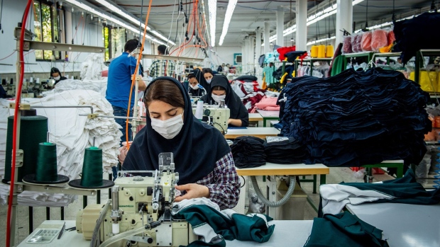 Workers wearing protective face masks manufacture Iranian brand clothing, including Koi designed garments, at a factory on the outskirts of Tehran, Iran, on Wednesday, Oct. 14, 2020. "Made in Iran" has emerged as a rare glimmer of hope in the financial destruction from being ostracised from the oil market and global trade while Covid-19 rages.