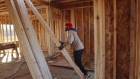 A contractor moves wooden beams to frame interior walls while working at a home under construction at The Estates at Kelley Farms new housing development in Ballston Lake, New York, U.S., on Friday, Dec. 11, 2020. The U.S. Census Bureau is scheduled to release housing starts figures on December 17.