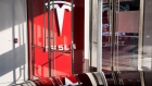 Signage is displayed at the entrance to the new Tesla Inc. showroom in New York. Photographer: Mark Kauzlarich/Bloomberg
