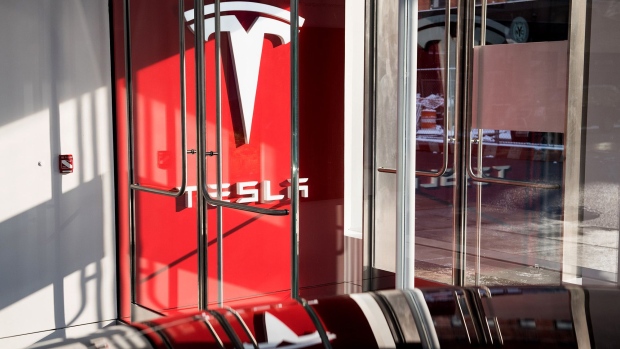 Signage is displayed at the entrance to the new Tesla Inc. showroom in New York. Photographer: Mark Kauzlarich/Bloomberg