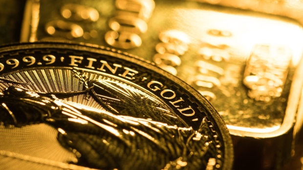 A one-ounce Britannia gold coin sits on one hundred gram gold bars at Gold Investments Ltd. bullion dealers in this arranged photograph in London, U.K., on Wednesday, July 29, 2020. Gold held its ground after a record-setting rally as investors awaited the outcome of a Federal Reserve meeting amid expectations policy makers will remain dovish, potentially spurring more gains. Photographer: Chris Ratcliffe/Bloomberg