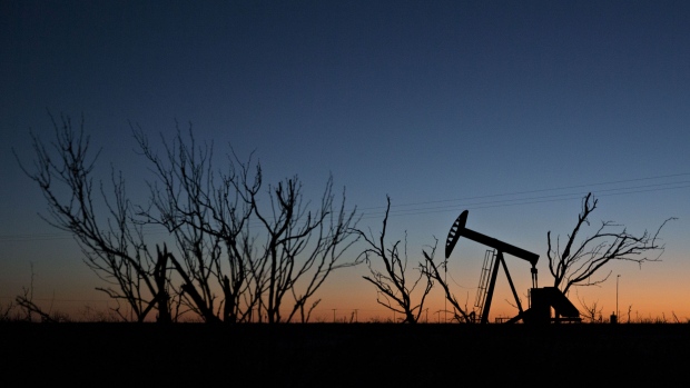 The silhouette of a pumpjack is seen at dusk in the Permian Basin near Midland, Texas, U.S., on Friday, March 2, 2018. Chevron, the world's third-largest publicly traded oil producer, is spending $3.3 billion this year in the Permian and an additional $1 billion in other shale basins. Its expansion will further bolster U.S. oil output, which already exceeds 10 million barrels a day, surpassing the record set in 1970. Photographer: Daniel Acker/Bloomberg