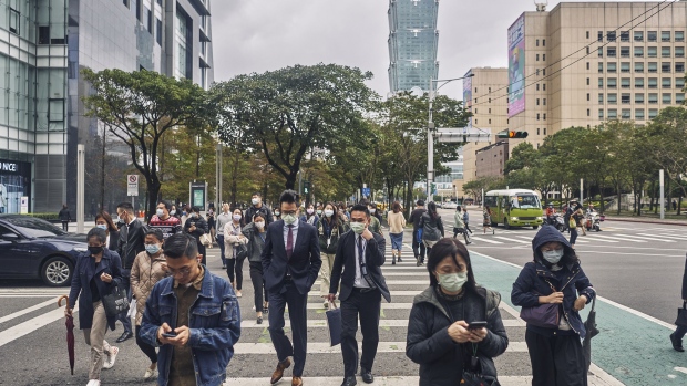 Pedestrians wearing face masks cross a street on December 02, 2020 in Taipei, Taiwan. Taiwan imposed mandatory mask-wearing regulations in some circumstances, including on transport services and in markets and restaurants, as it tries to keep its record of controlling Covid-19 infections in check. (Photo by An Rong Xu/Getty Images)