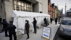 Healthcare workers wait in line outside a Toronto vaccination clinic on Dec. 15, 2020.