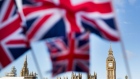 FILE: A display of U.K., Union Jack flags fly in front of The Houses of Parliament, in London, U.K., on Monday, Feb. 15, 2016.