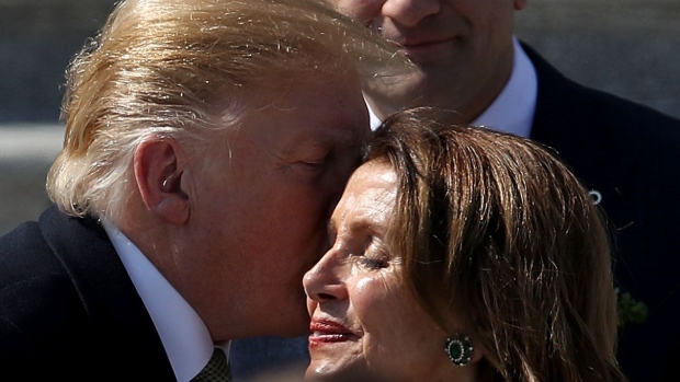 WASHINGTON, DC - MARCH 14: U.S. President Donald Trump kisses Speaker of the House Nancy Pelosi (D-CA) while departing the U.S. Capitol following a St. Patrick's Day celebration on March 14, 2019 in Washington, DC. (Photo by Win McNamee/Getty Images)