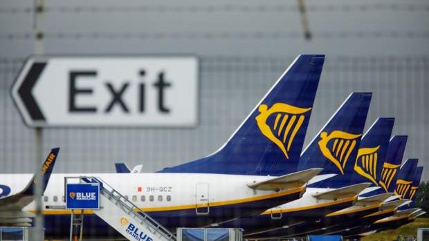 Passenger aircraft operated by Ryanair Holdings Plc stands on the tarmac near a road sign that reads "exit" at London Stansted Airport, operated by Manchester Airport Plc, in Stansted, U.K., on Thursday, July 9, 2020. EasyJet Plc is considering cutting a third of its pilot positions and may eliminate three bases in the U.K., including London's Stansted airport, in reaction to a business slump that the discount carrier doesn’t expect to rebound for another three years.