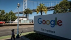 A pedestrian wearing a protective mask walks past signage at the Google San Francisco office in San Francisco, California, U.S., on Monday, July 27, 2020. Alphabet Inc.'s Google will let employees work from home until July 2021, once again pushing back the re-opening of its offices as the coronavirus continues to rage in many parts of the U.S. Photographer: David Paul Morris/Bloomberg