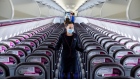 A member of flight crew sits next to social distancing signs at London’s Heathrow Airport. Photographer: Chris Ratcliffe/Bloomberg