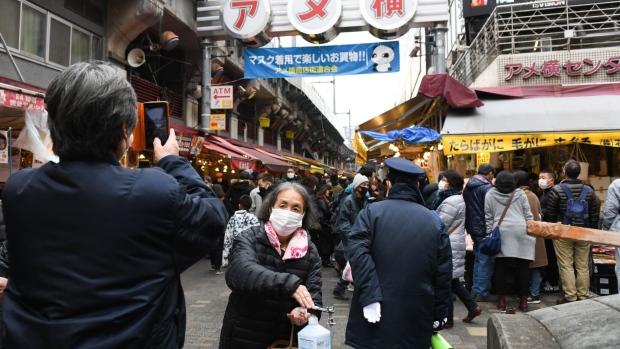 People wearing protective face masks wait in line to offer prayers on the first business day of the year at the Kanda Myojin shrine in Tokyo, Japan, on Monday, Jan. 4, 2021. Japanese stocks declined on the first trading day of the year following reports of a state of emergency, with the benchmark Topix Index falling as much as 1.6%. Photographer: Soichiro Koriyama/Bloomberg