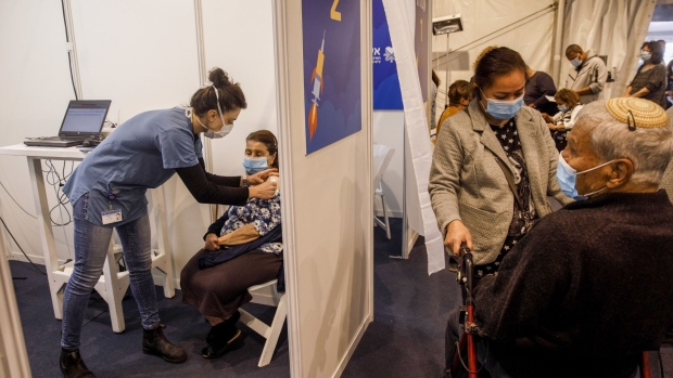 A nurse administers a dose of the Pfizer-BioNTech Covid-19 vaccine to a person inside a cubicle at a Covid-19 mass vaccination center at Rabin Square in Tel Aviv, Israel, on Monday, Jan. 4, 2020. Israel plans to vaccinate 70% to 80% of its population by April or May, Health Minister Yuli Edelstein said on Monday, pressing ahead with a program that promises an earlier-than-forecast economic recovery.