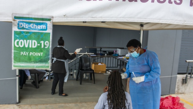 A medical worker speaks with a patient at a walk-in and drive-thru coronavirus testing facility in Pretoria. Photographer: Waldo Swiegers/Bloomberg