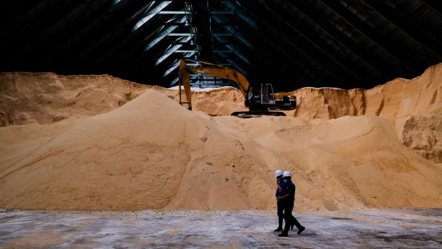 Employees walk past stockpiles of raw sugar inside a warehouse at the MSM Malaysia Holdings Bhd. sugar refinery in Pasir Gudang, Johor, Malaysia, on Friday, Aug. 21, 2020. Malaysia's economy began to show signs of recovery at the tail end of the last quarter. Manufacturing production and sales growth turned positive in June and the unemployment rate fell to 4.9%.