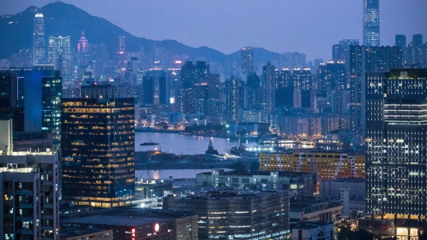 A construction site in the Kai Tak area, center, stands among illuminated buildings at dusk in Hong Kong, China, on Thursday, Feb. 20, 2020. Apartment rents in Hong Kong have dropped to the lowest in almost two years as people leave the city and home owners try to lease rather than sell. Photographer: Billy H.C. Kwok/Bloomberg