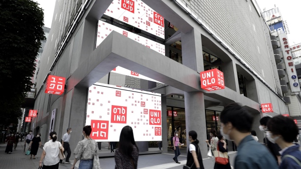 Pedestrians walk past the Uniqlo Tokyo flagship store, operated by Fast Retailing Co., in the Ginza district of Tokyo, Japan, on Thursday, June 18, 2020. Uniqlo joins a constellation of businesses seeking to offer new products and services as the coronavirus pandemic upends lifestyles around the globe, changing how people work, dress and eat.