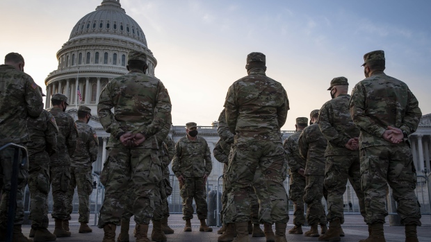 Members of the National Guard stand behind a fence in front of the U.S. Capitol in Washington, D.C., U.S., on Wednesday, Jan. 13, 2021. President Donald Trump was impeached by the U.S. House on a single charge of incitement of insurrection for his role in a deadly riot by his supporters that left five dead and the Capitol ransacked, putting an indelible stain on his legacy with only a week left in his term.