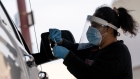 A healthcare worker wearing personal protective equipment (PPE) places a Covid-19 swab test into a vial at a United Airlines testing sire inside San Francisco International Airport (SFO) in San Francisco, California, U.S., on Thursday, Jan. 9, 2021. California reported 459 daily virus deaths, the second-highest tally since the pandemic began, as the most-populous state continues to battle a surge of cases that has strained health-care facilities. Photographer: David Paul Morris/Bloomberg