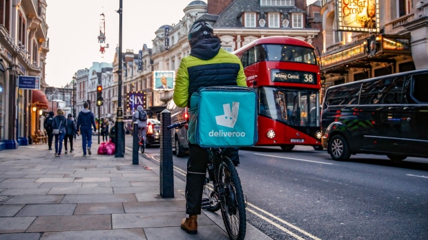 A takeaway food courier, working for Deliveroo, operated by Roofoods Ltd., cycles in the Soho district of London, U.K., on Tuesday, Sept. 29, 2020. Covid-19 lockdown enabled online and app-based grocery delivery service providers to make inroads with customers they had previously struggled to recruit, according the Consumer Radar report by BloombergNEF. Photographer: Hollie Adams/Bloomberg