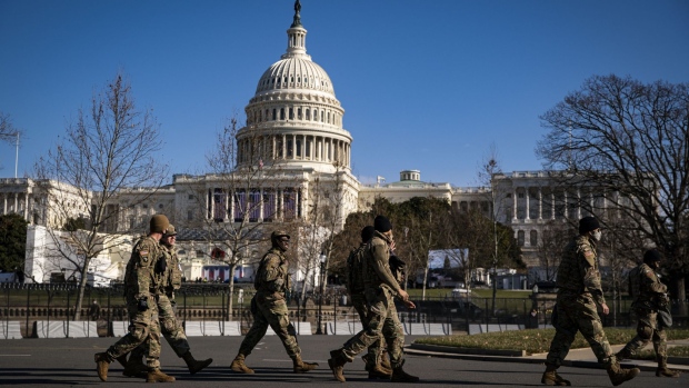 Members of the National Guard walk past a security perimeter outside the U.S. Capitol as preparations are made ahead of the presidential inauguration in Washington, D.C., U.S., on Saturday, Jan. 16, 2021. The U.S. capital is getting even more fortified with the help of patrolling by uniformed National Guard forces as federal, state and local officials brace for a worst-case scenario of violence tied to the Jan. 20 inauguration.