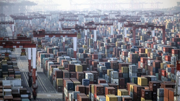 Shipping containers next to gantry cranes at the Yangshan Deepwater Port in Shanghai, China, on Monday, Jan, 11, 2021.