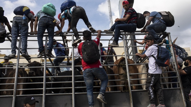 Honduran migrants climb onto a truck while traveling to the Guatemalan border near La Entrada, Honduras, on Friday, Jan. 15, 2021. Guatemalan troops, police and health workers are setting up 16 checkpoints across the country to try to detect migrants traveling to the U.S. border from Honduras. Photographer: Nicolo Filippo Rosso/Bloomberg