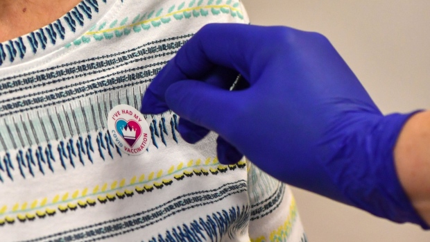 A patient is given a sticker after receiving the AstraZeneca Plc and the University of Oxford Covid-19 vaccine at the Royal Health & Wellbeing Centre in Oldham, U.K., on Thursday, Jan. 21, 2021. Boris Johnson's government is pinning its hopes on a mass vaccination program to reduce hospitalizations and ultimately deaths, and aims to slowly lift restrictions from March to allow the economy to re-open. Photographer: Anthony Devlin/Bloomberg