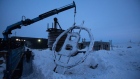 A crane arm lifts a bitcoin sculpture made from scrap metal as it is installed outside the BitCluster cryptocurrency mining farm in Norilsk, Russia, on Sunday, Dec. 20, 2020. Norilsk may soon be famous for a different type of mining — it now hosts the Arctic's first crypto farm for producing new Bitcoins. Photographer: Andrey Rudakov/Bloomberg