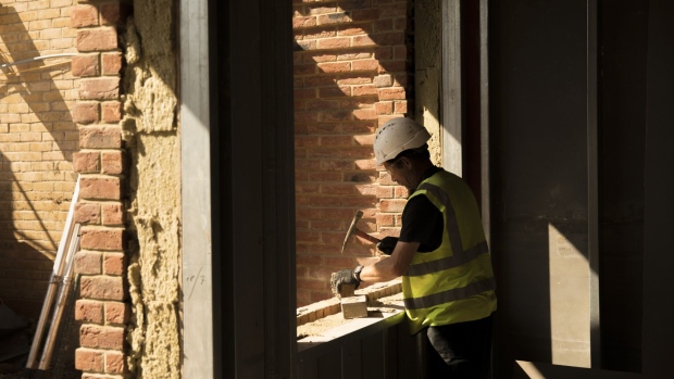 A bricklayer chips a brick into shape while working on a residential construction site in the Tower Hamlets district of London, U.K., on Monday, July 29, 2019. High living costs and a falling pound are further deterrents for EU citizens considering settling in Britain. Photographer: Jason Alden/Bloomberg